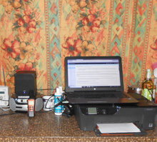 Photo of laptop and a small speaker on a kitchen countertop